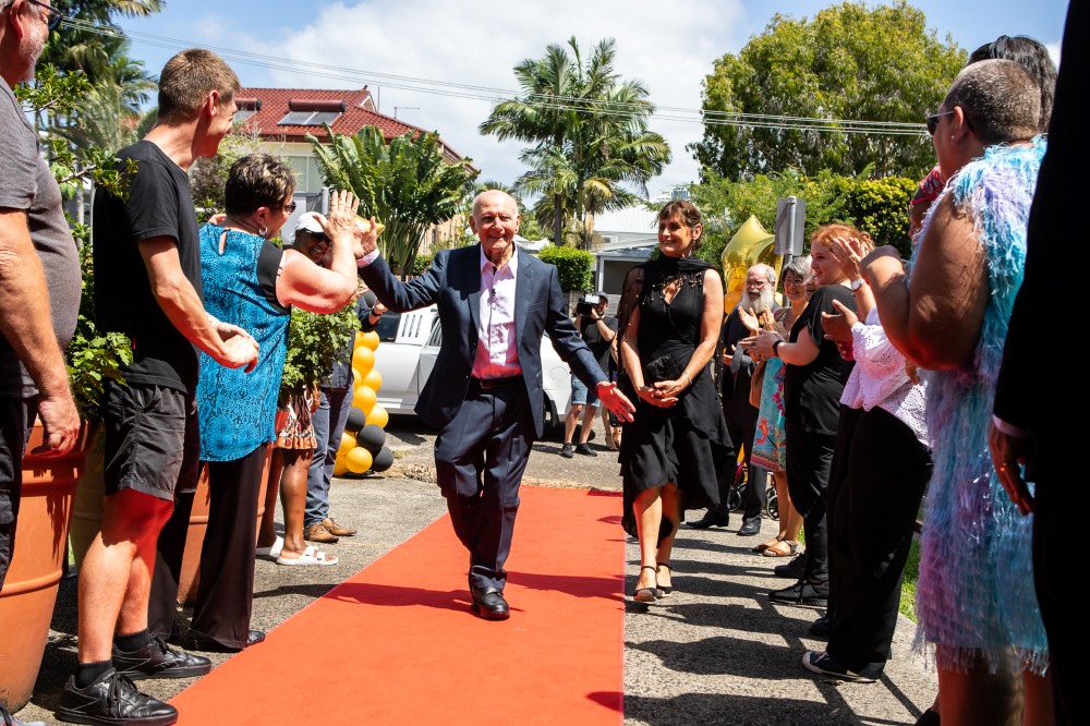 Elderly man in suit walking on red carpet