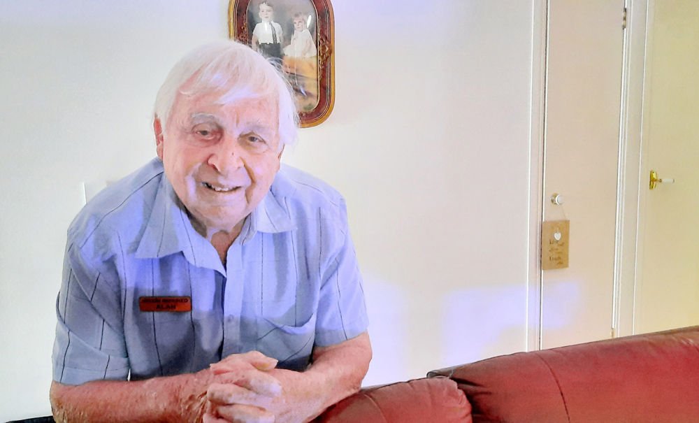 Senior man leaning on the back of a couch