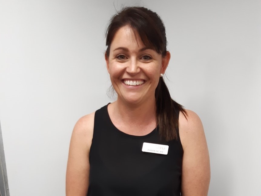 Brunette middle aged woman smiling for camera in black