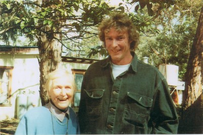 Old scanned film photo of a man and an elderly lady smiling at the camera