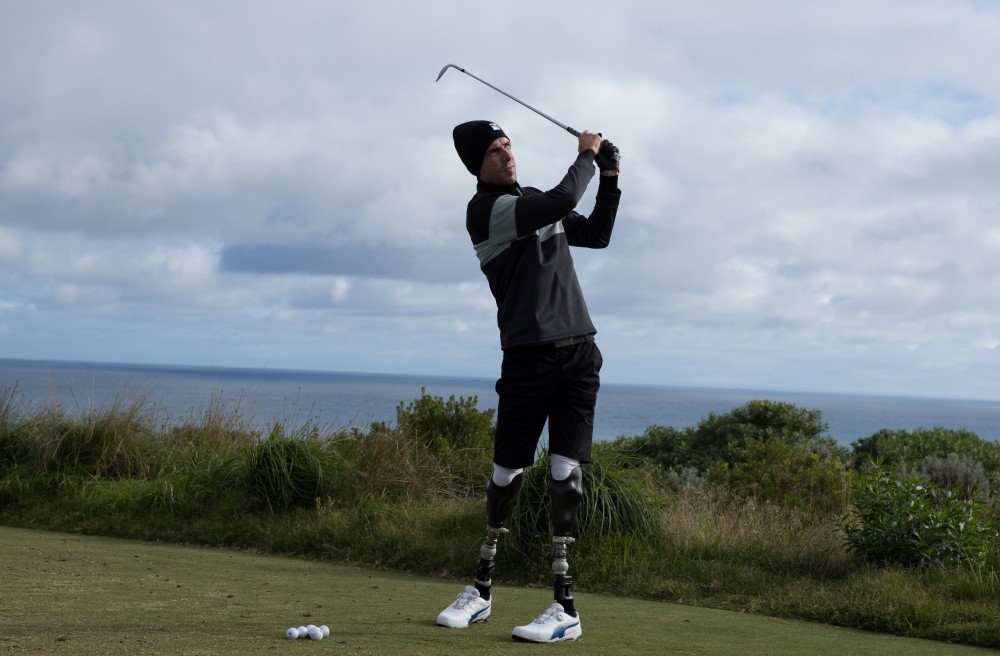 Double leg amputee playing golf outside