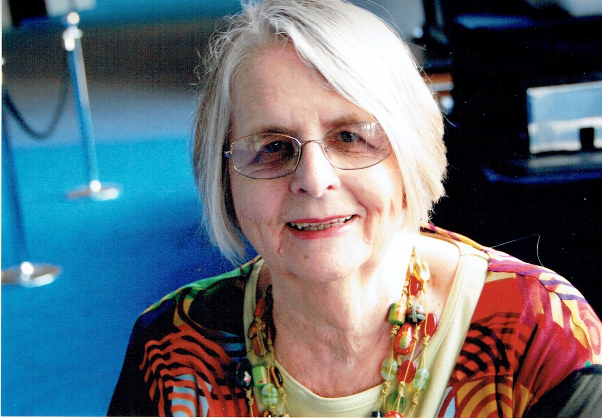 Senior lady with grey bob and glasses smiling at camera