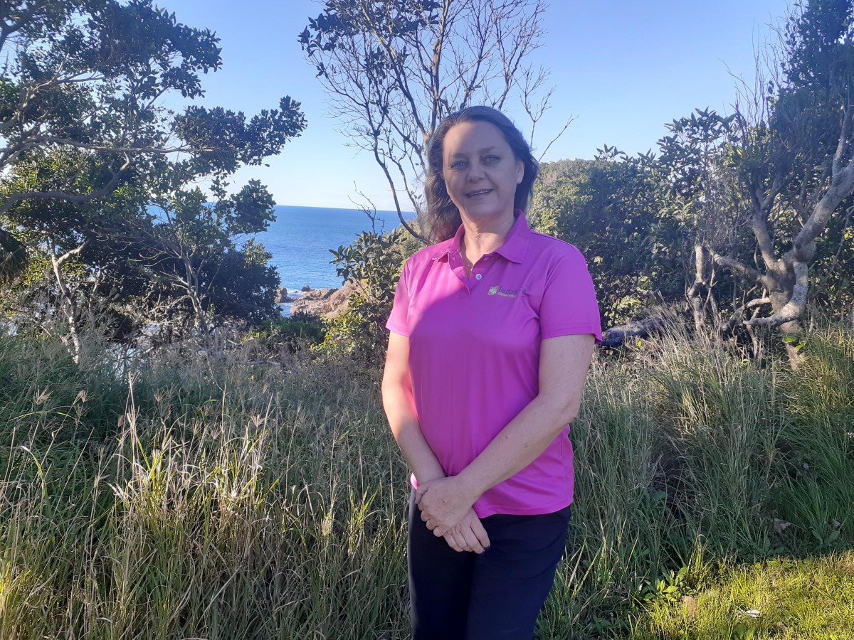 Woman in bright pink T-shirt standing outside