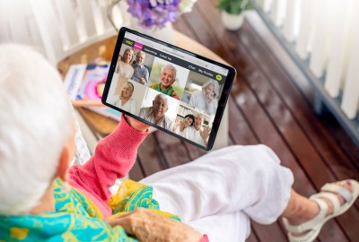 Senior lady looking down at virtual call on her tablet