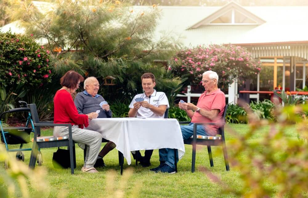 Group of seniors playing cards outside