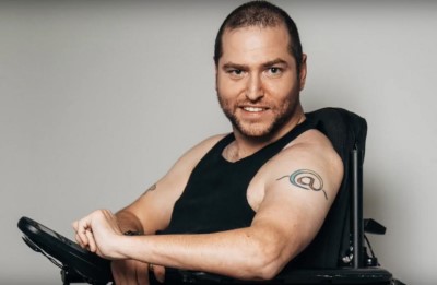 Man in wheelchair grinning at camera