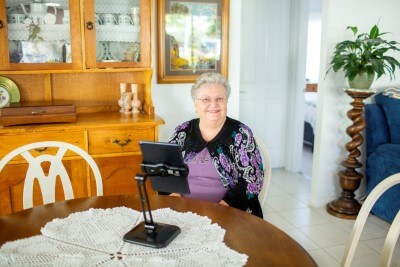 Female sitting with tablet looking at camera