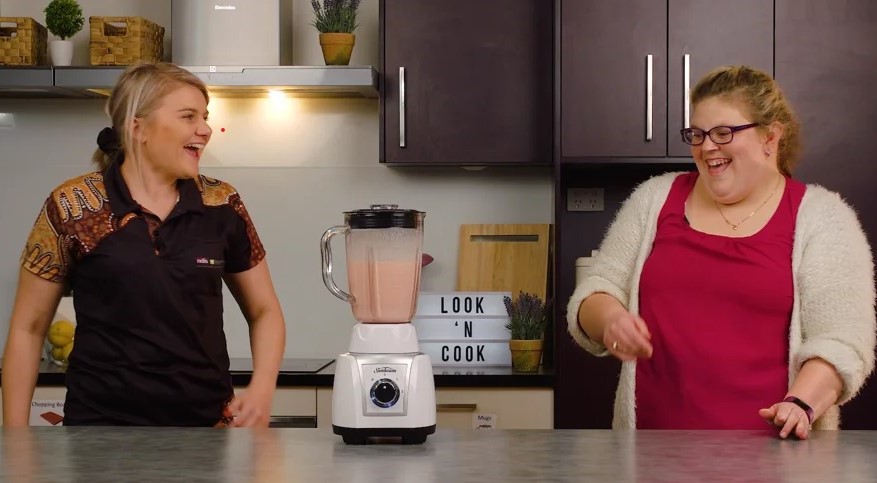 Two women laughing in kitchen