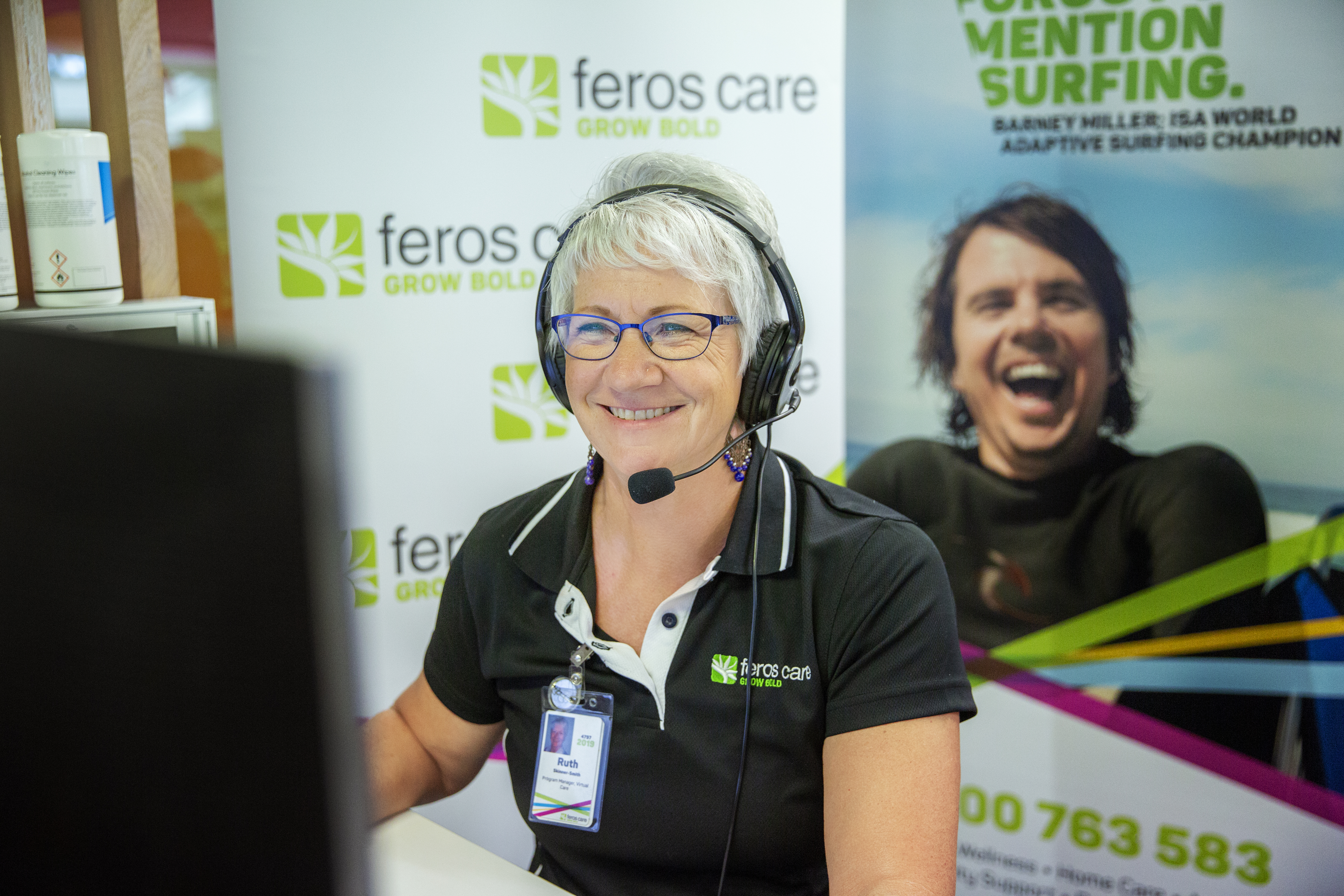 Call centre lady with headphones looking at screen