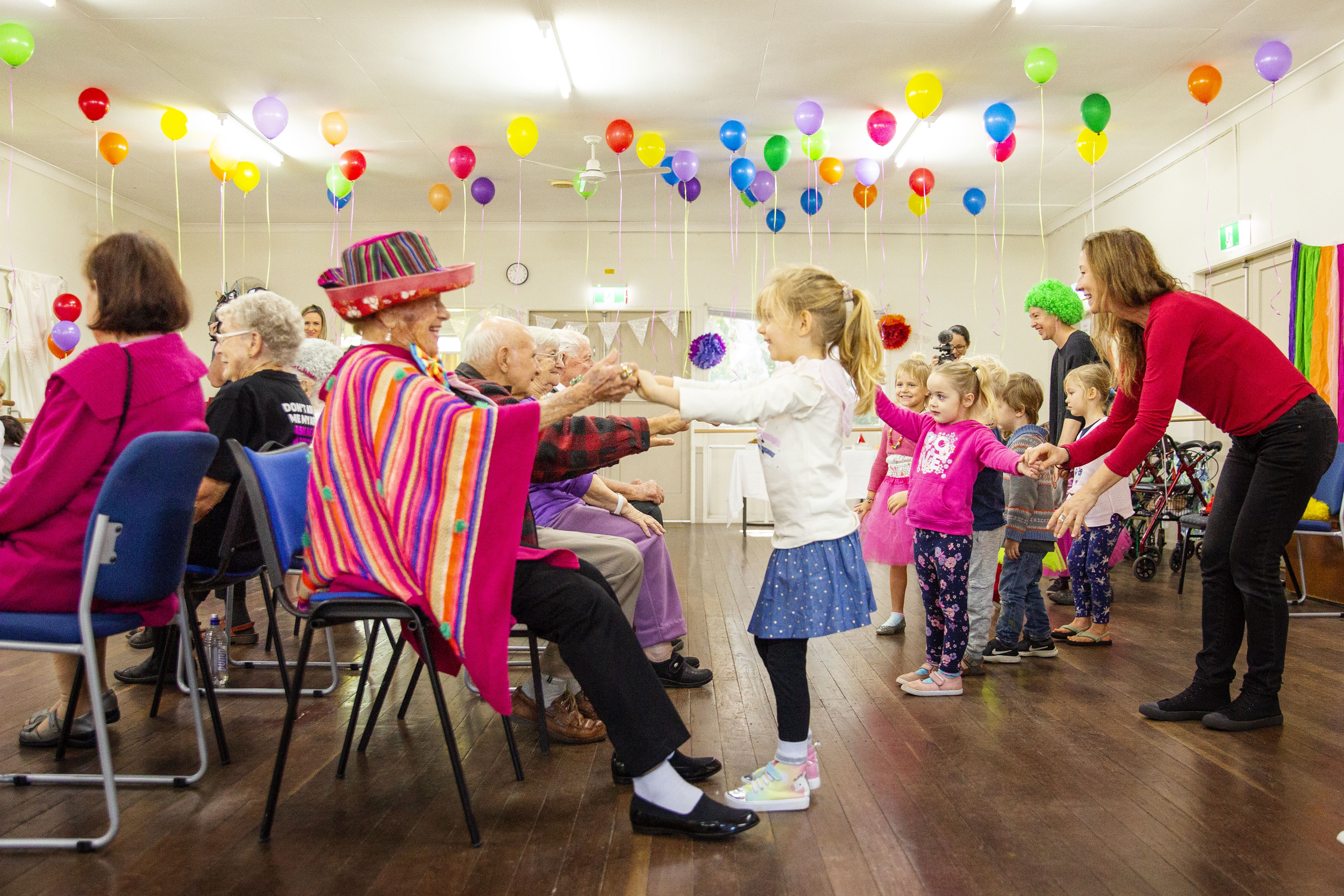 Senior lady dancing with little girl 