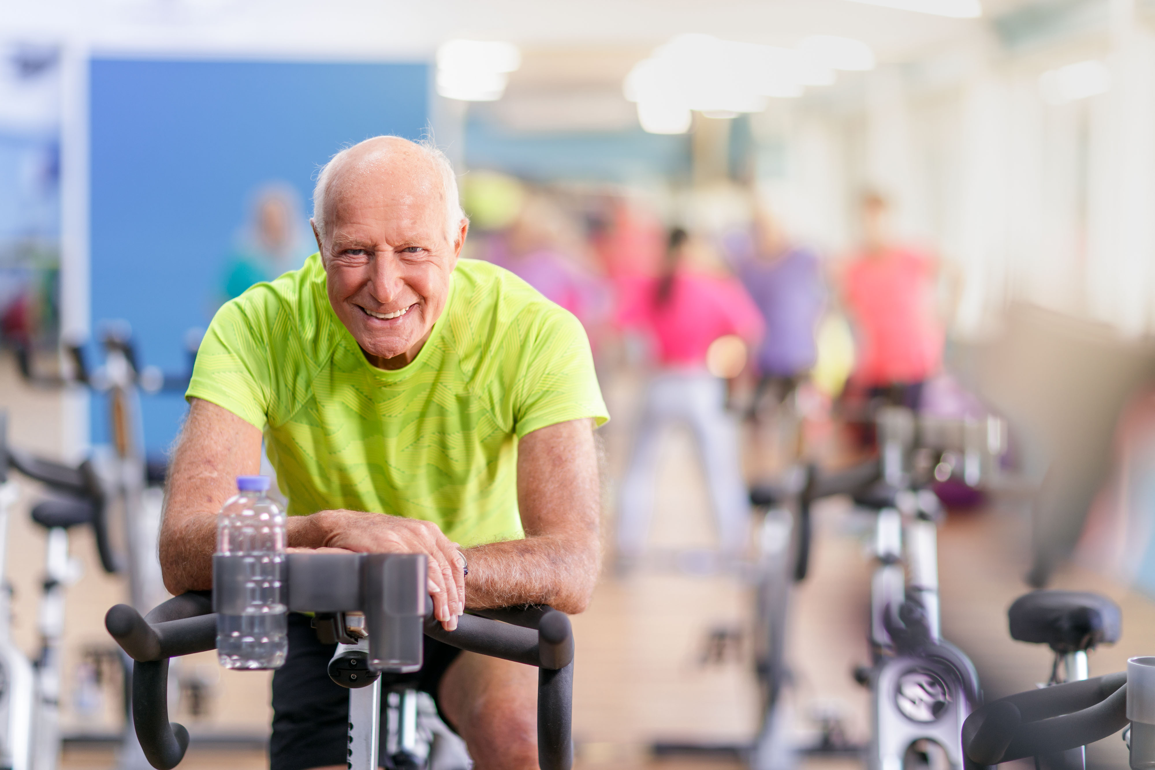 Grandpa wearing lime green smiling on stationary bike- closeup