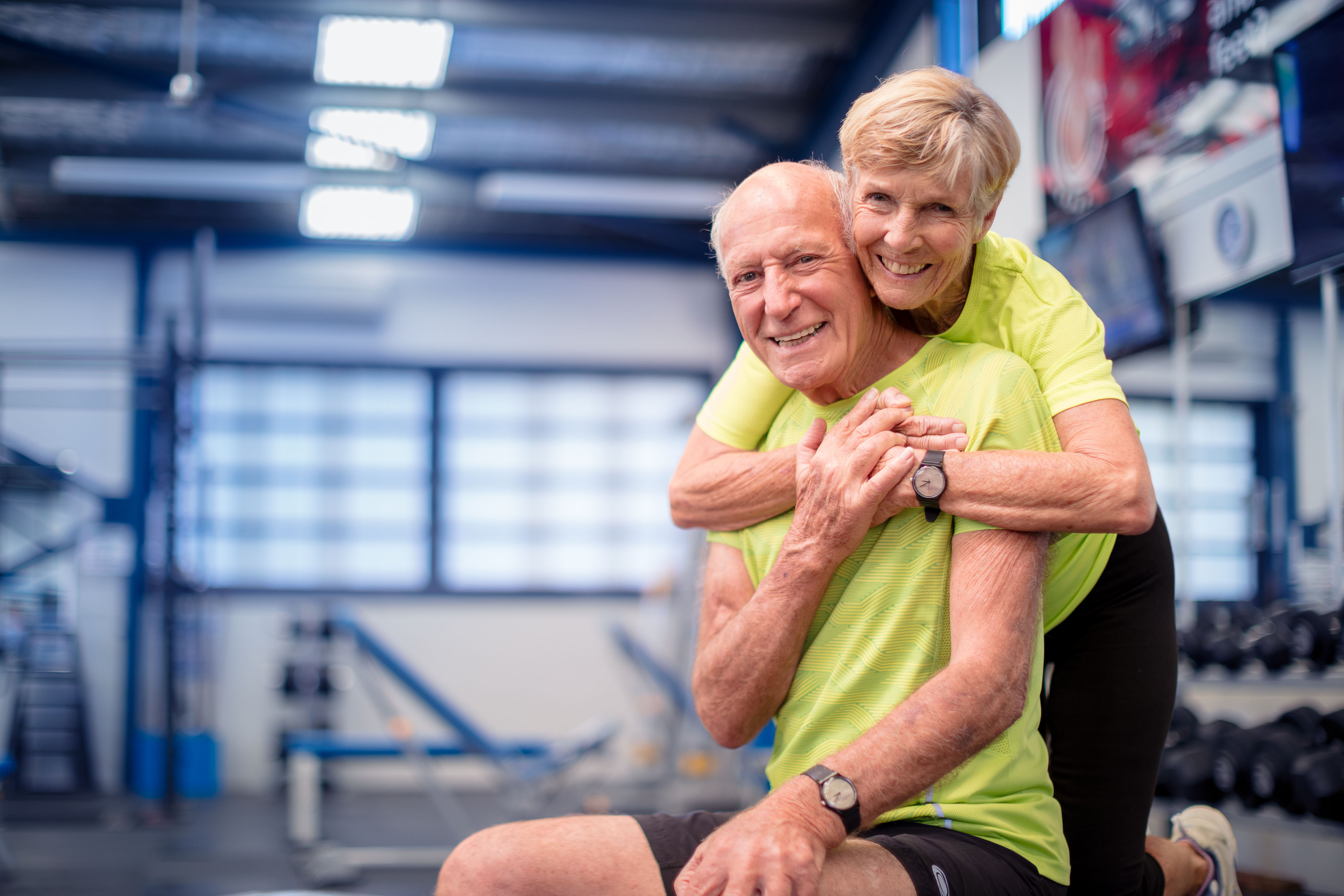 Happy couple hugging in gym