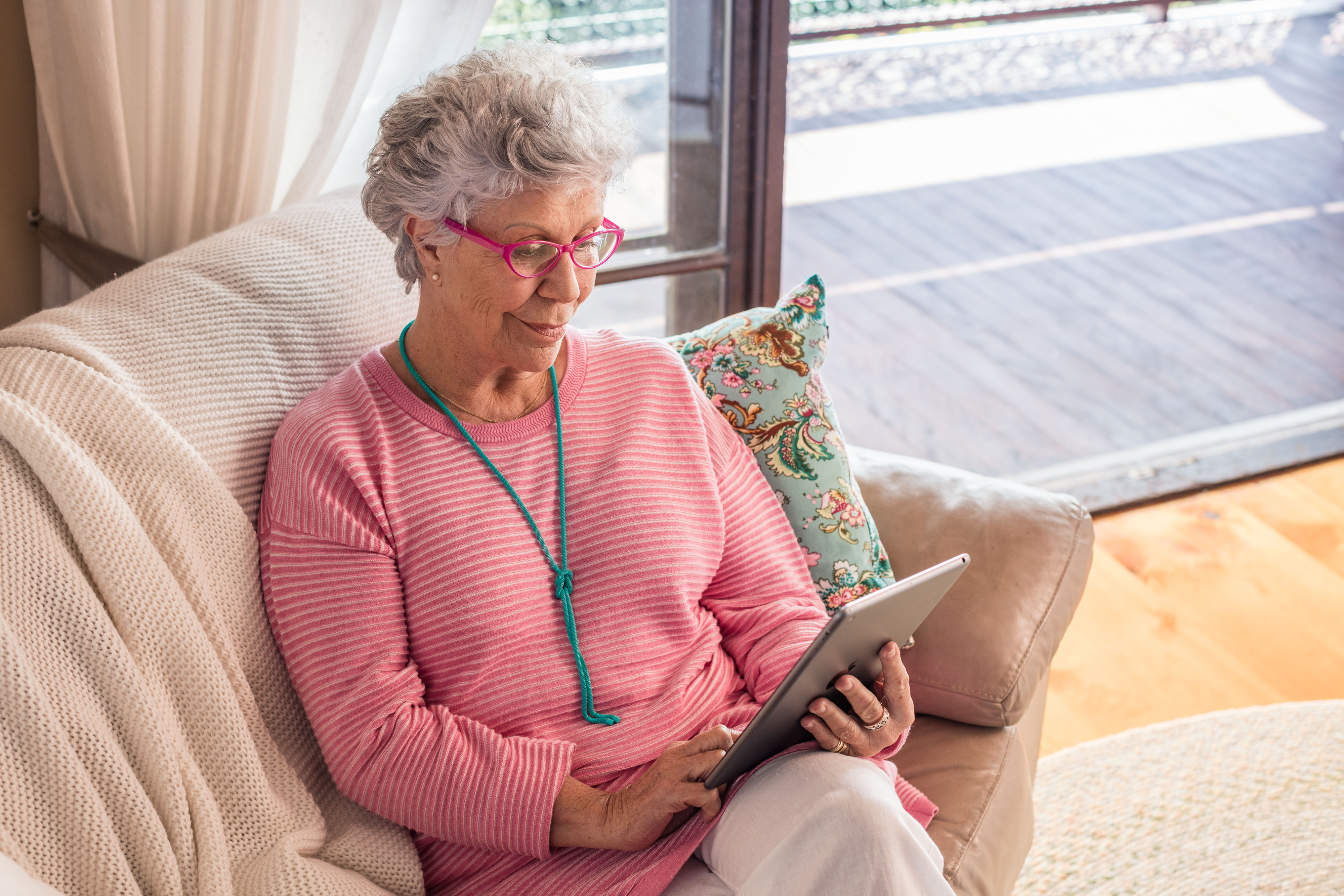 Lady sitting on lounge looking at ipad