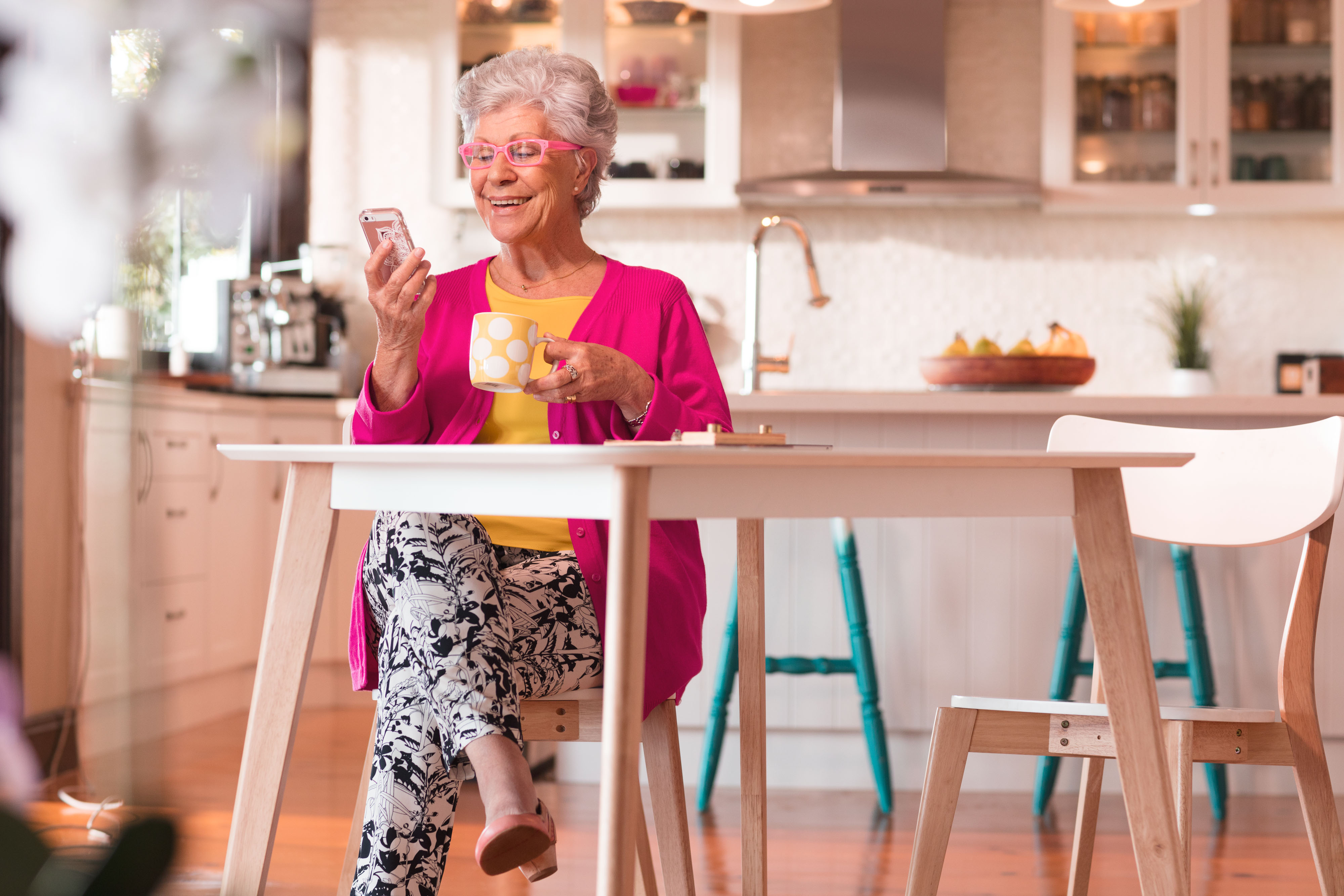  Lady with pink cardi having coffee looking at mobile phone