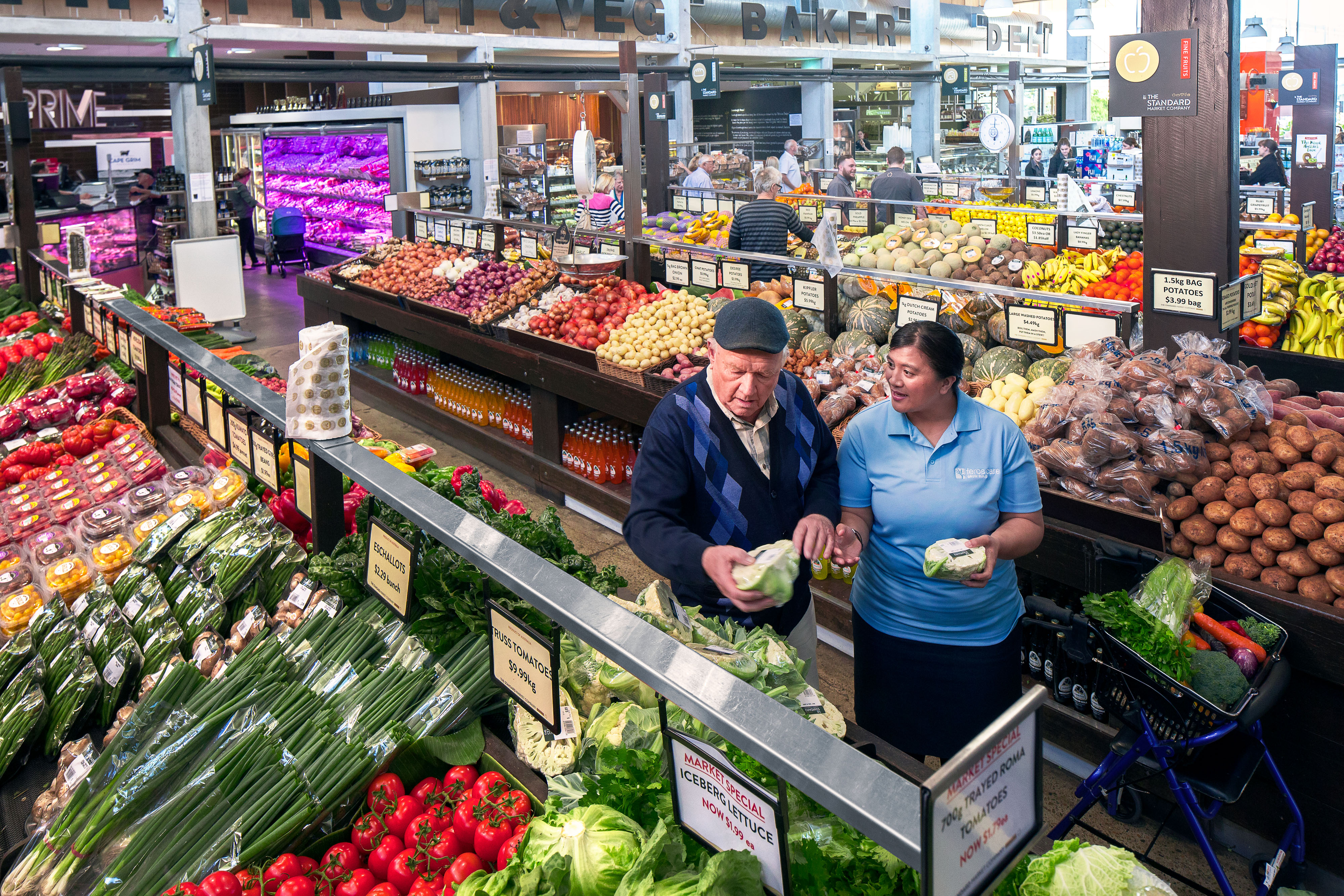 Man and lady in fruit shop buying cauliflower