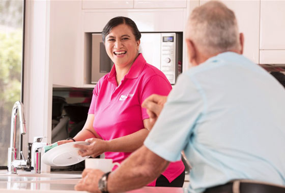 Care worker cleaning clients kitchen 