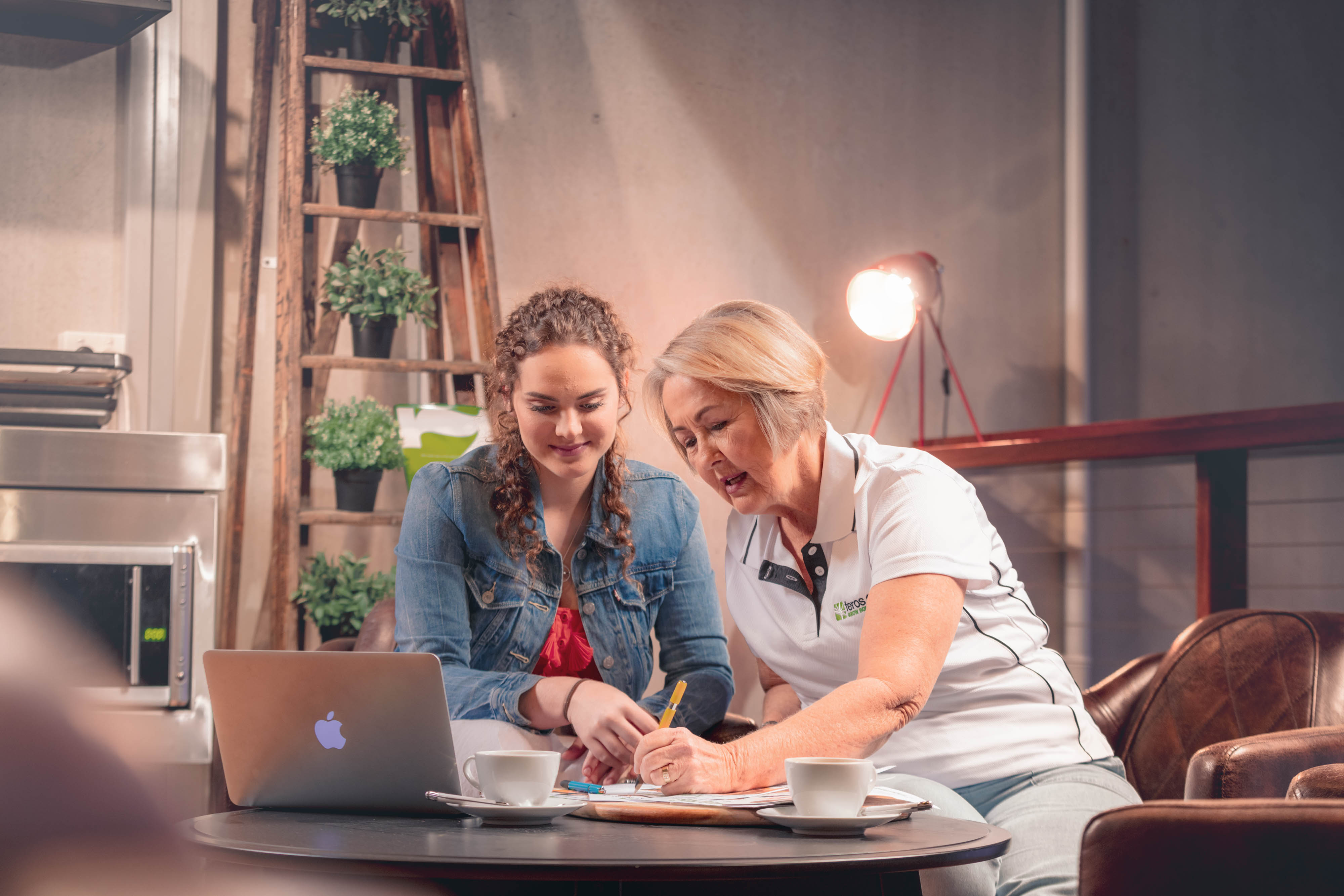 Woman with teenager writing on table