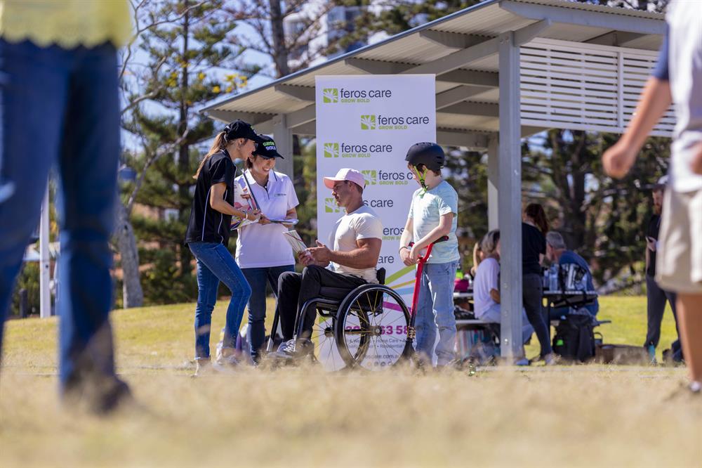 Man in wheelchair talking to women at expo Man in wheelchair talking to women at expo