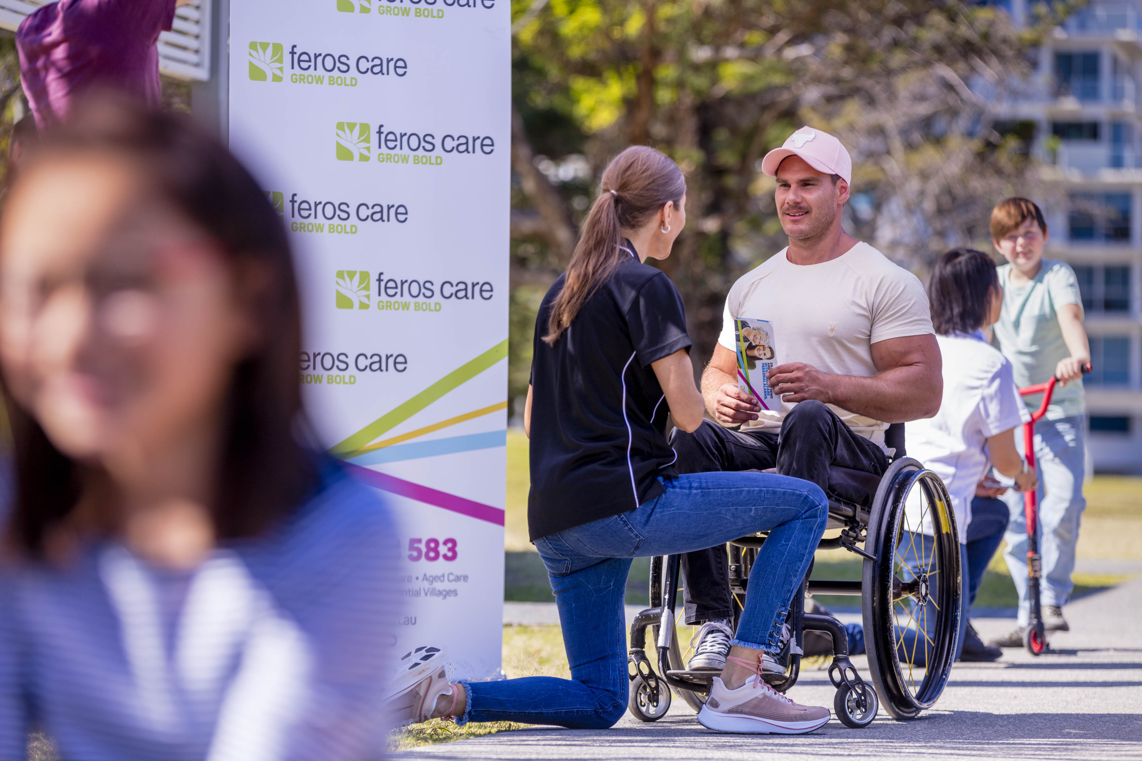 Woman talking to man in wheelchair outside