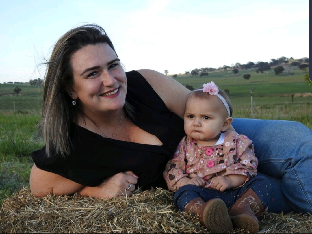 Woman with baby lying on hay bale