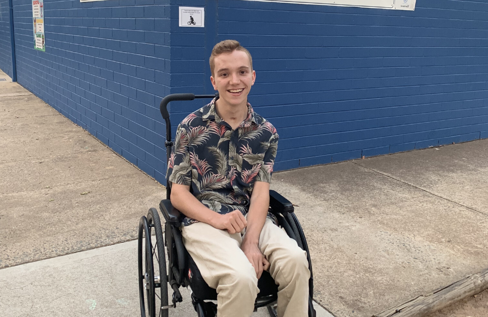 Boy sitting in wheelchair on school grounds