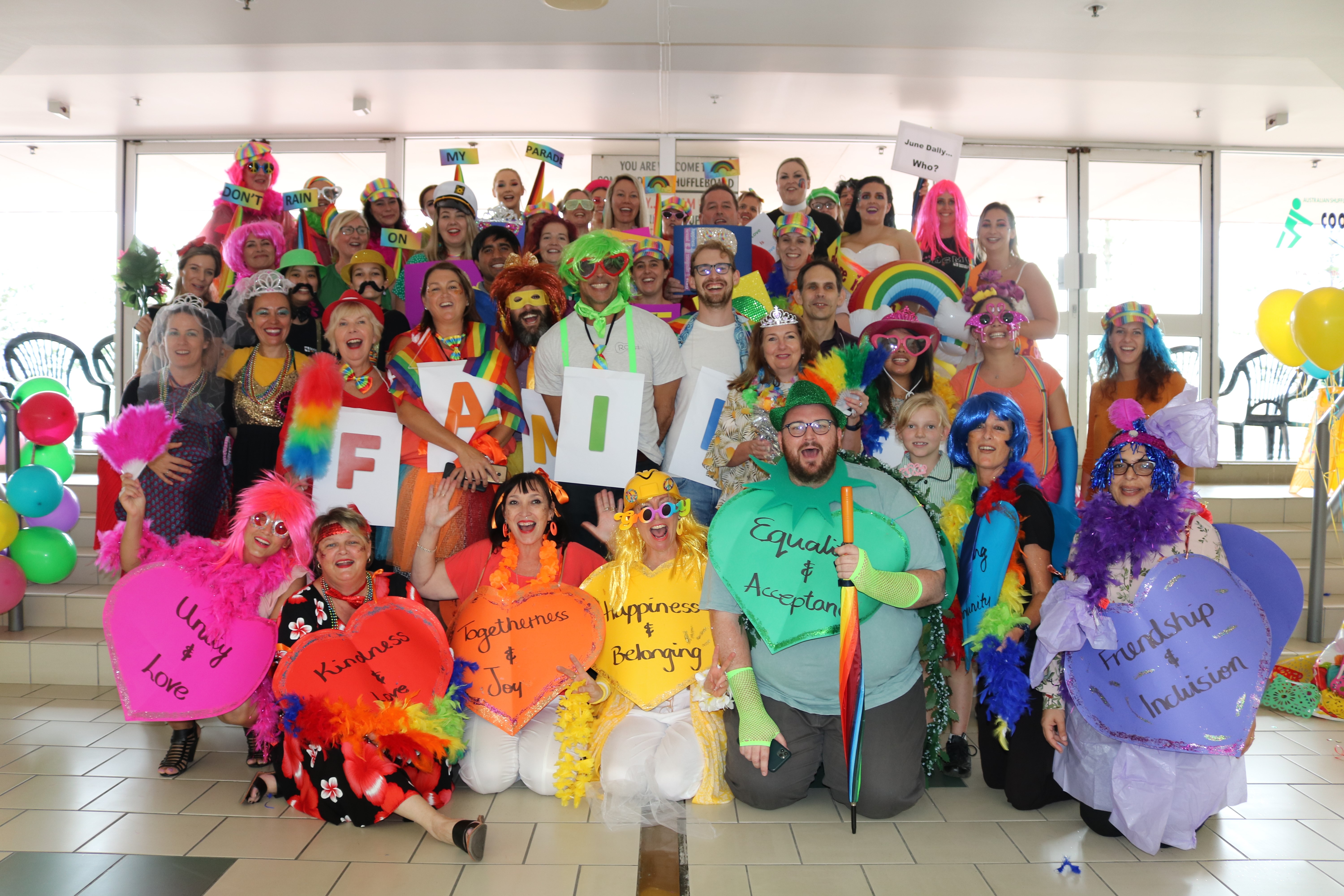 Group of people dressed up in the colours of the rainbow for Mardi Gras