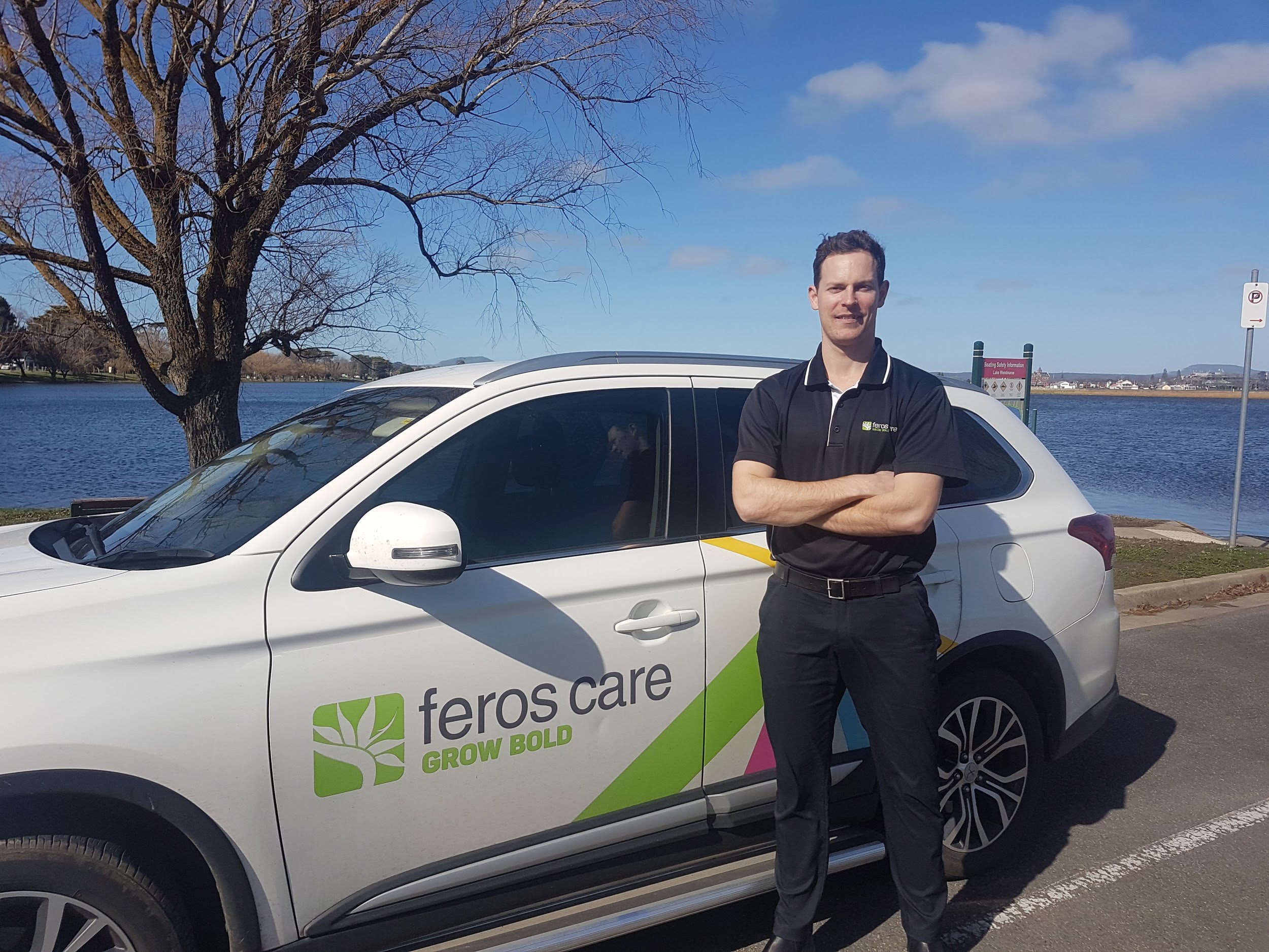 Man Standing next to Feros Care car