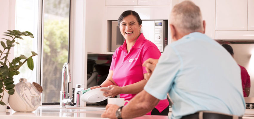 care worker cleaning clients kitchen 