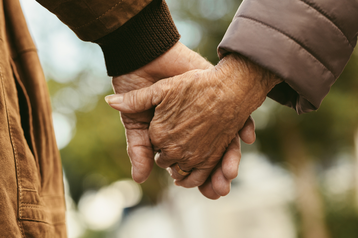 Old couple holding hands