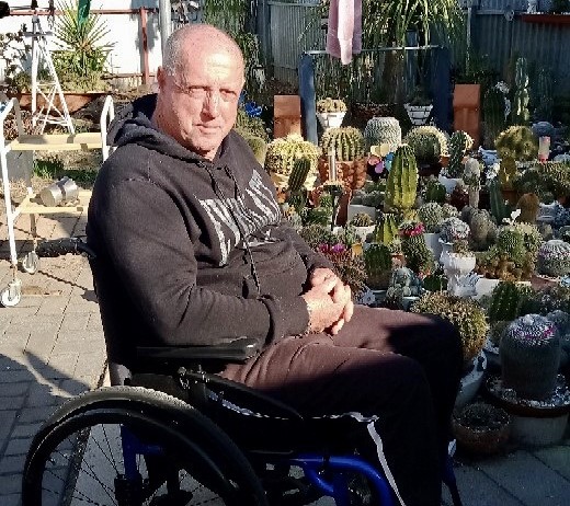 Man in wheelchair sitting outside in the sun 