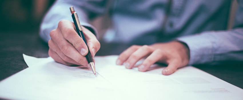 man writing in document 