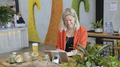 Woman talking to people on tablet in brewery