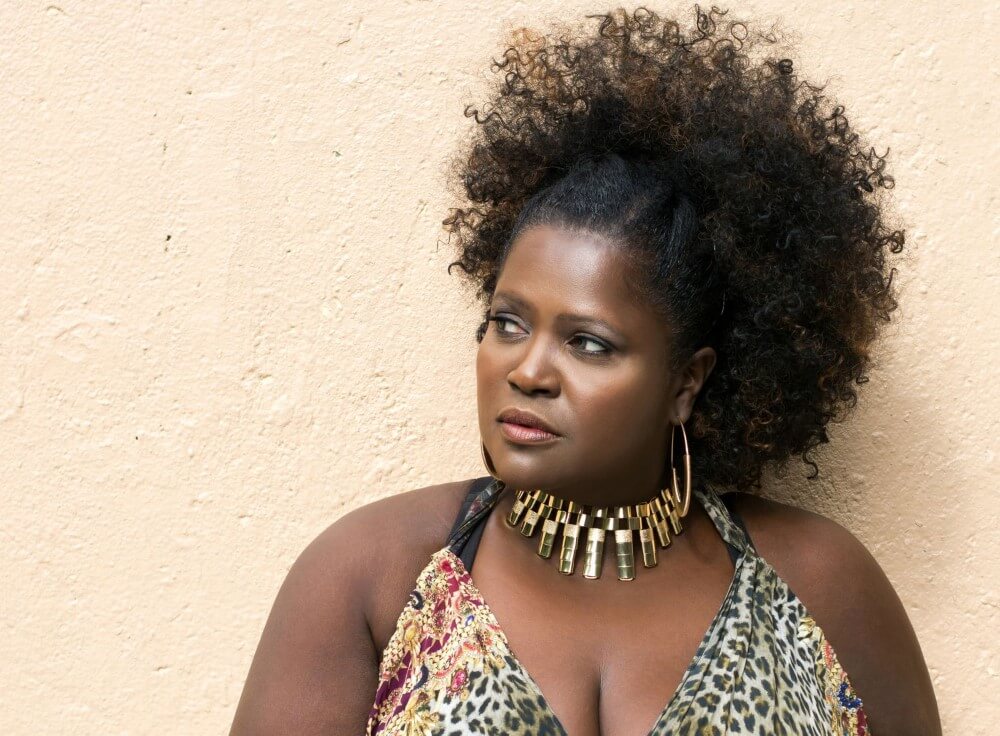 Black woman in animal print top and natural afro looking away from camera