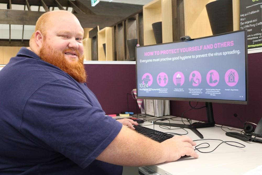 Man with ginger beard sits in front of computer screen