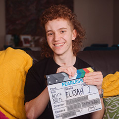 Photo: Elijah Arranz holding Fearless Films clapper board