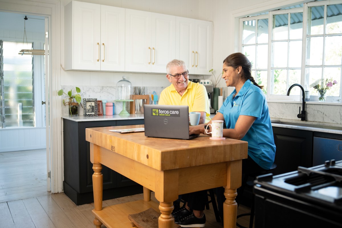 Female support worker with male client in kitchen