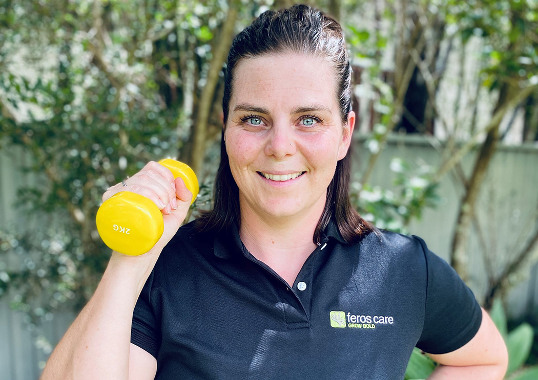 Kerry, a Feros Care Physiotherapist, holding up a 2 kilogram dumbbell