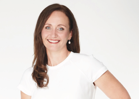 Brunette woman in white T-shirt smiling at camera