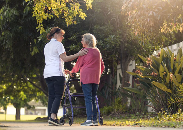 Senior walking with carer