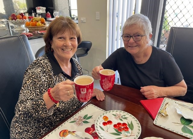 Two senior ladies having tea at a table